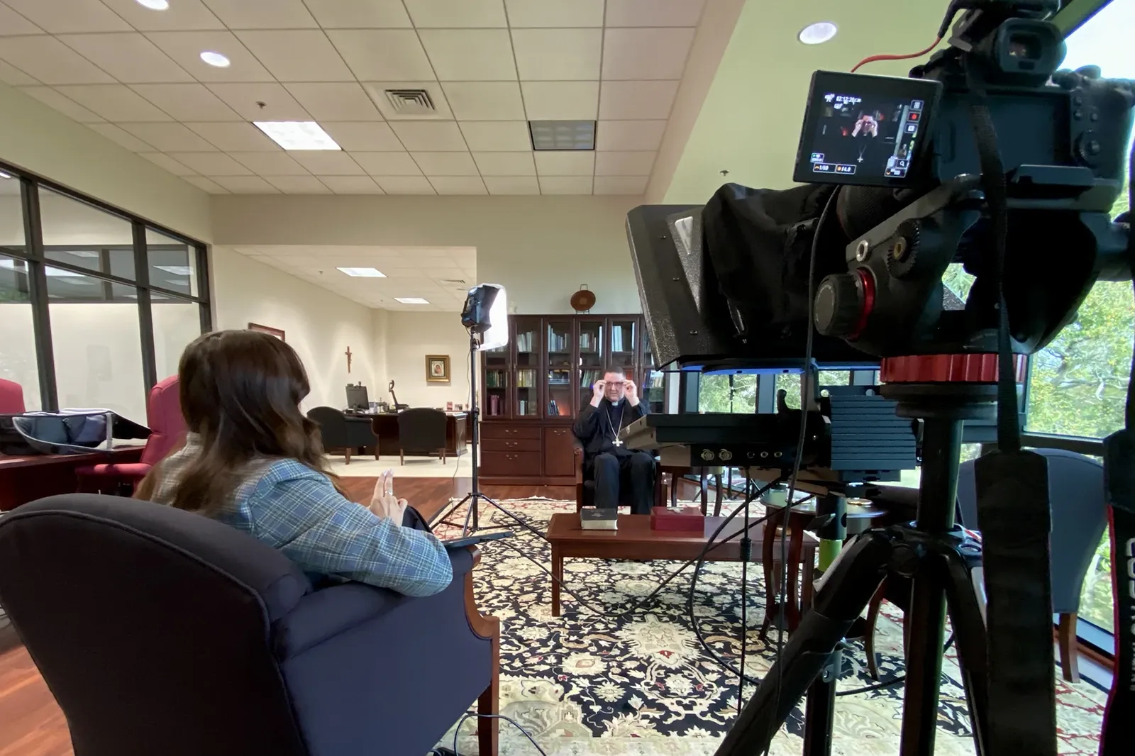 Behind-the-scenes view of the Diocese of St. Petersburg Easter Message production with the bishop, crew, and camera